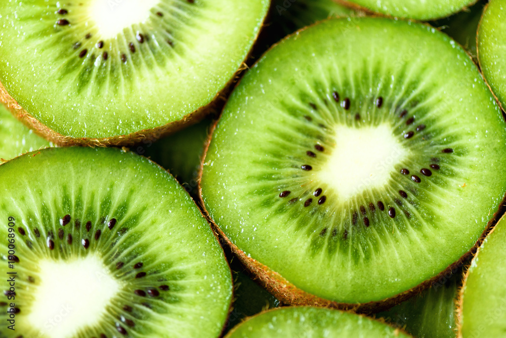 Fresh organic kiwi fruit sliced. Food frame with copy space for your text. Banner. Green kiwi circles background Fresh organic kiwi fruit sliced. Food frame with copy space for your text. Banner. Green kiwi circles background