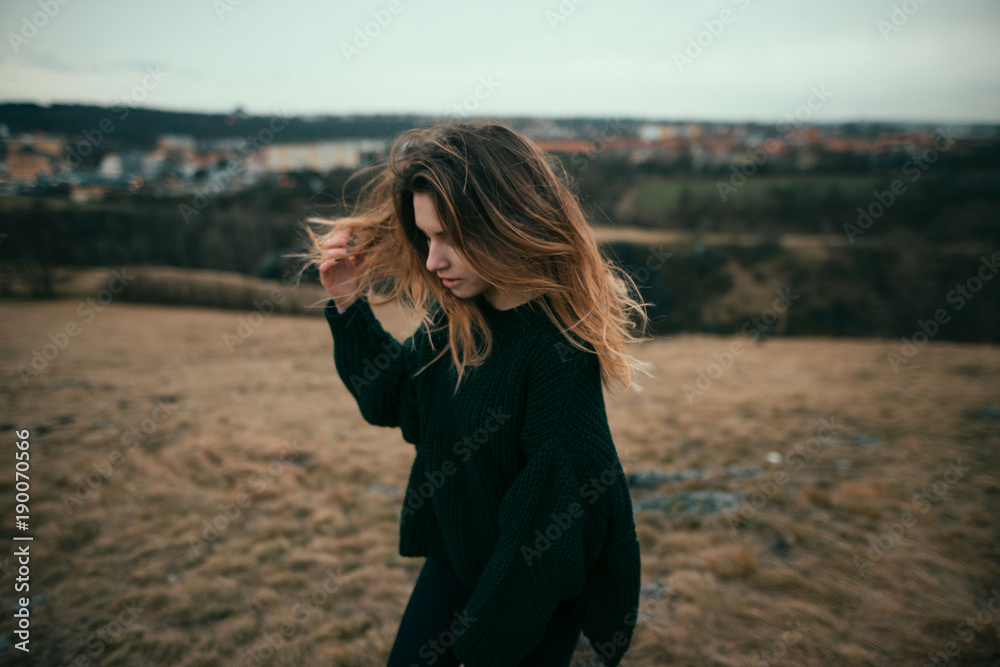 Cute girl with curly windy hair outdoor