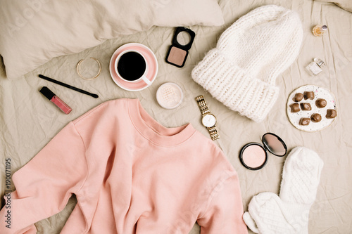 Female fashion look with stylish clothes and accessories. Beauty blog flat lay, top view composition with sweatshirt, cosmetics and coffee.