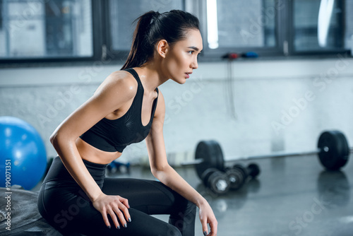 side view of attractive fit woman sitting on workout wheel after training at gym © LIGHTFIELD STUDIOS