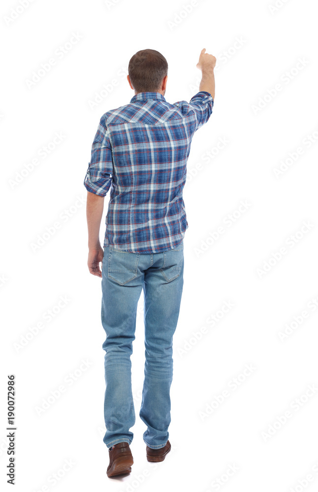Back view of going handsome man in jeans pointing. Back view of going handsome man in jeans pointing.