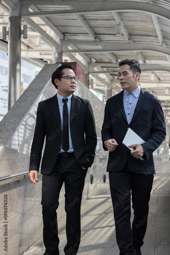 Businessman presenting work to boss, leader about planning project outside building. Businessman presenting work to boss, leader about planning project outside building.