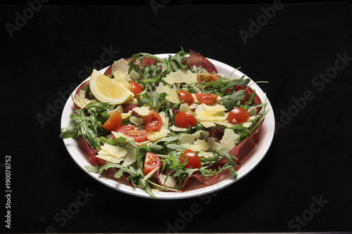 bresaola with rocket salad, tomatoes and parmesan cheese.