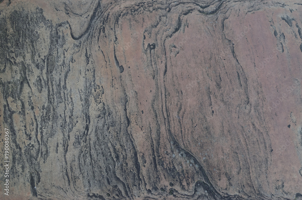An abstract view of a flat, weathered stone surface suitable for use as a texture or background