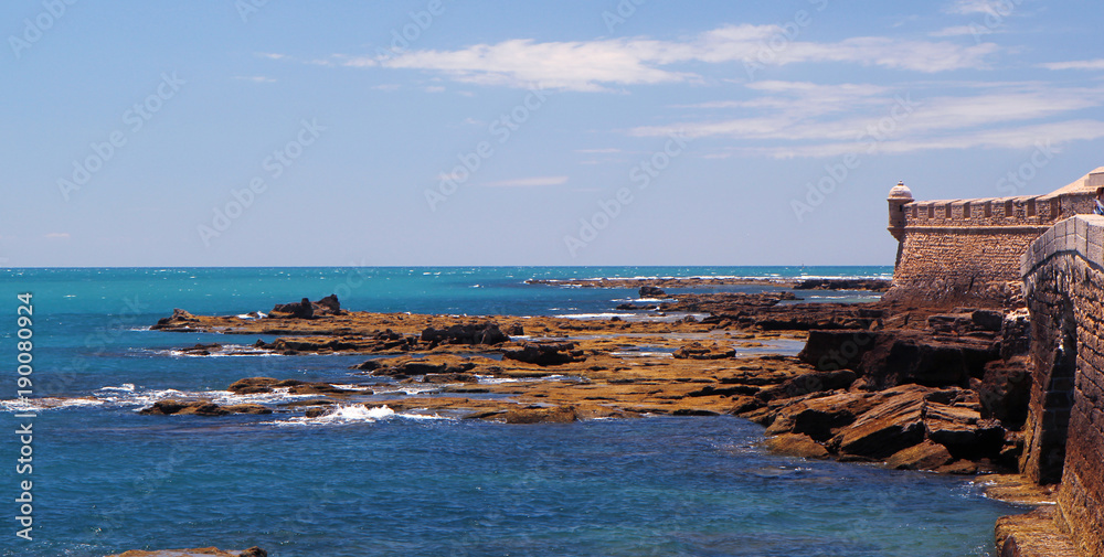 Rocky oceanic coastline and ancient fortress walls