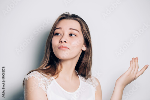 Beautiful woman with a sneer on his face on a white background. Smiling, mocking. photo