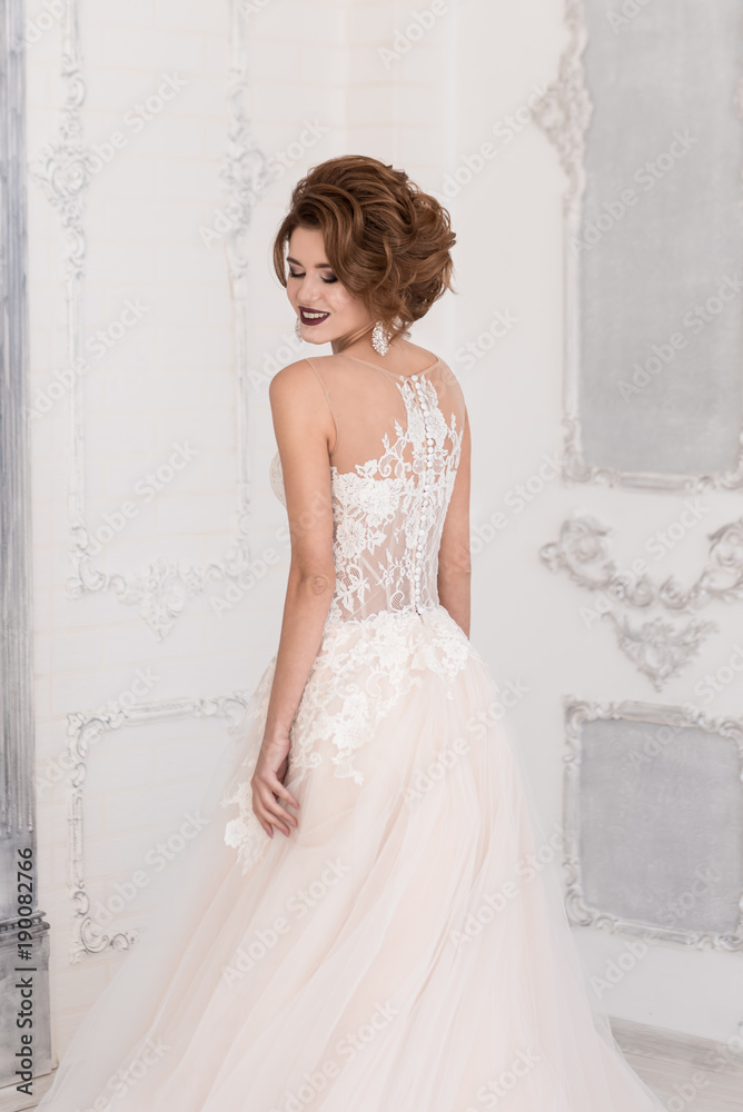 Morning of the bride. A beautiful bride stands with her back in her wedding dress. Morning of the bride. A beautiful bride stands with her back in her wedding dress.