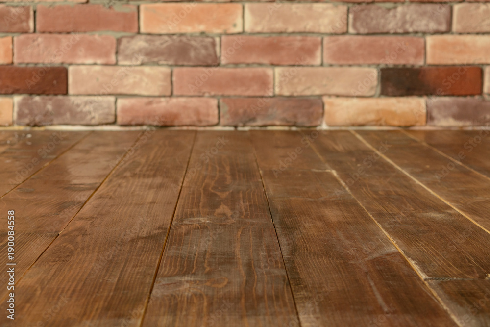 Brown wooden floor with brick wall background with copy space