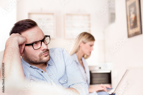 Angry man because his girlfriend looking at laptop