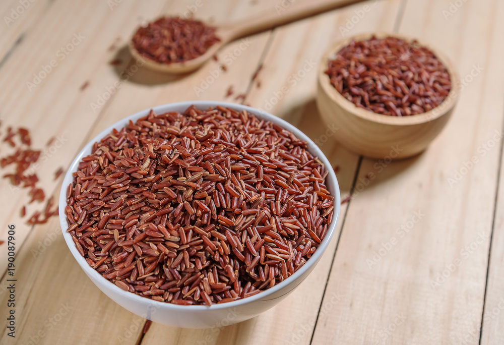 Rice berry in wooden bowl on wood background Rice berry in wooden bowl on wood background