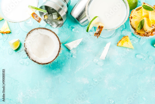 Tropical drink, Frozen Coconut Pineapple Margaritas with frozen pina colada, tequila, pineapple juice and lime, light blue background, copy space top view