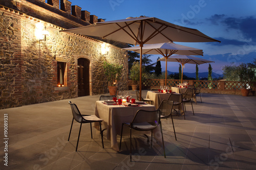 outdoor dinner tables with candles and shade umbrellas in the countryside