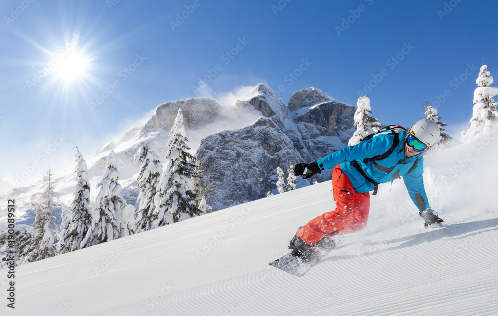 Young man snowboarder running downhill in Alps - obrazy, fototapety, plakaty 