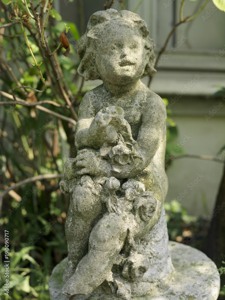 old children statue profile in a garden