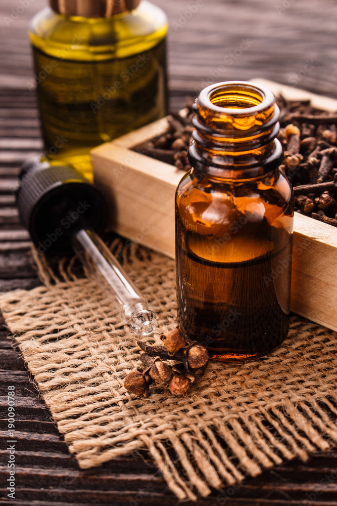 essential oil of cloves on a wooden rustic background