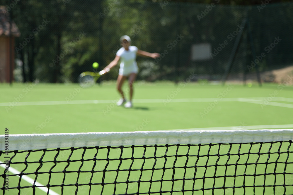 blurred woman playing tennis in a green field blurred woman playing tennis in a green field