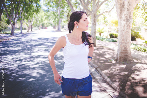 Foto Beautiful brunette female fitness model running / stretching / exercising outsid