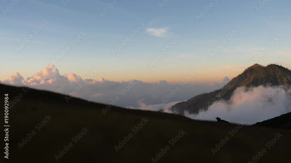 Tops of the mountains covered with forest in running clouds and fog at sunrise. Landscape slopes of the mountains with the forest in the morning fog and clouds.Slopes of the mountains are covered with Tops of the mountains covered with forest in running clouds and fog at sunrise. Landscape slopes of the mountains with the forest in the morning fog and clouds.Slopes of the mountains are covered with