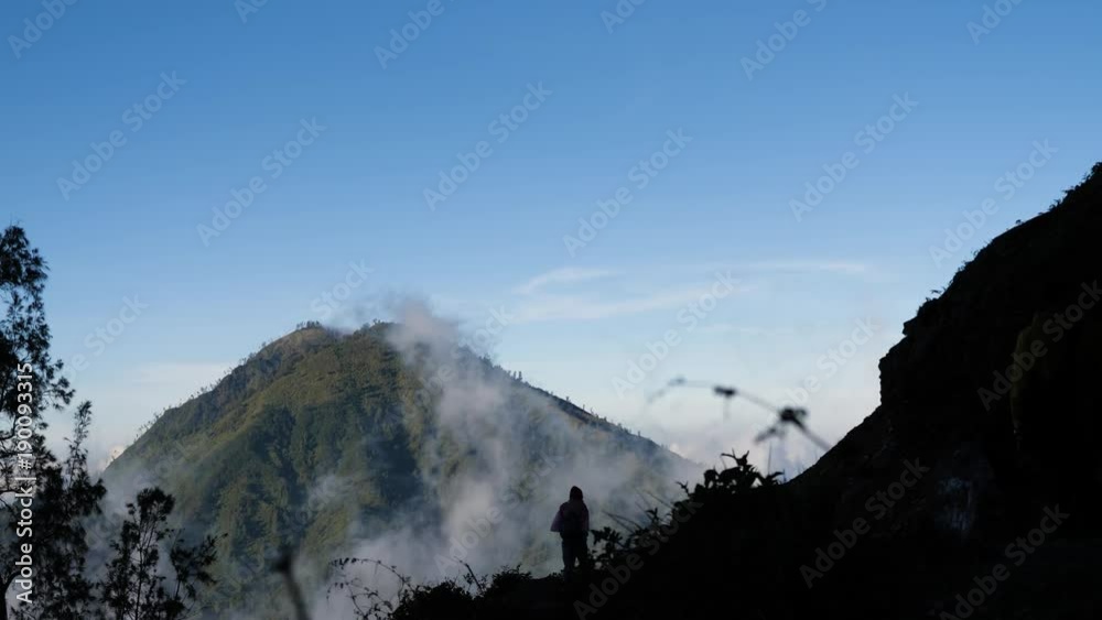 Tops of the mountains covered with forest in running clouds and fog at sunrise. Landscape slopes of the mountains with the forest in the morning fog and clouds.Slopes of the mountains are covered with Tops of the mountains covered with forest in running clouds and fog at sunrise. Landscape slopes of the mountains with the forest in the morning fog and clouds.Slopes of the mountains are covered with