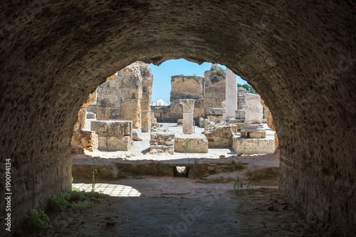 View through arch to archaeological site. Ancient columns of marble and thermal baths in Carthage. Tunisia