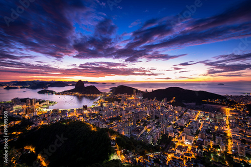 Rio de Janeiro city just before sunrise with city lights on, and the Sugarloaf Mountain in the horizon