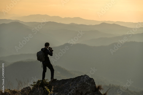 Photographer with camera in hand on top of mountain. © aedkafl