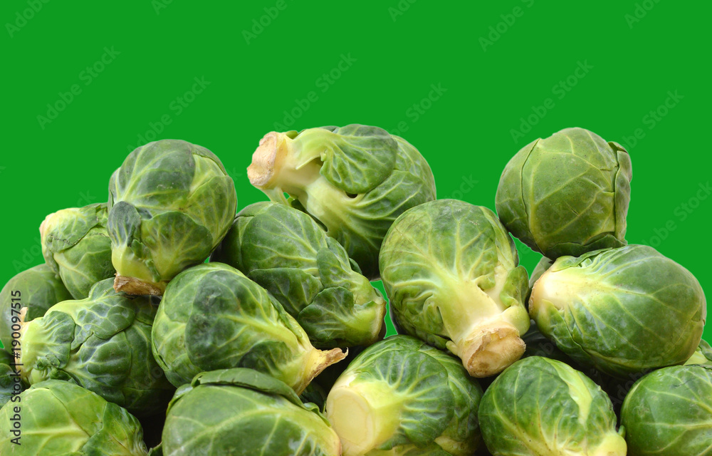 freshly brussel sprouts and some whole ones on a green background