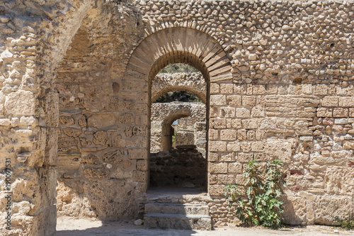 The arch in the stone wall of Sandstone. Ancient masonry. The Ruins Of Carthage In Tunisia