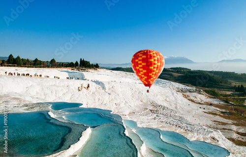 Hot air balloon flying over Travertine pools limestone terraces in Pamukkale, Denizili, Turkey photo