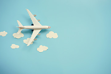 Flat lay design of travel concept with plane and cloud on blue background with copy space.