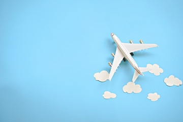 Flat lay design of travel concept with plane and cloud on blue background with copy space.