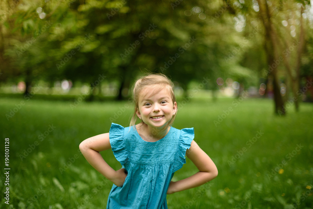 Happy girl is having fun in a blue dress in the park Happy girl is having fun in a blue dress in the park