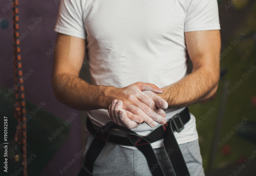 Unrecognizable sportsman sprinkling hands with talc Unrecognizable sportsman sprinkling hands with talc