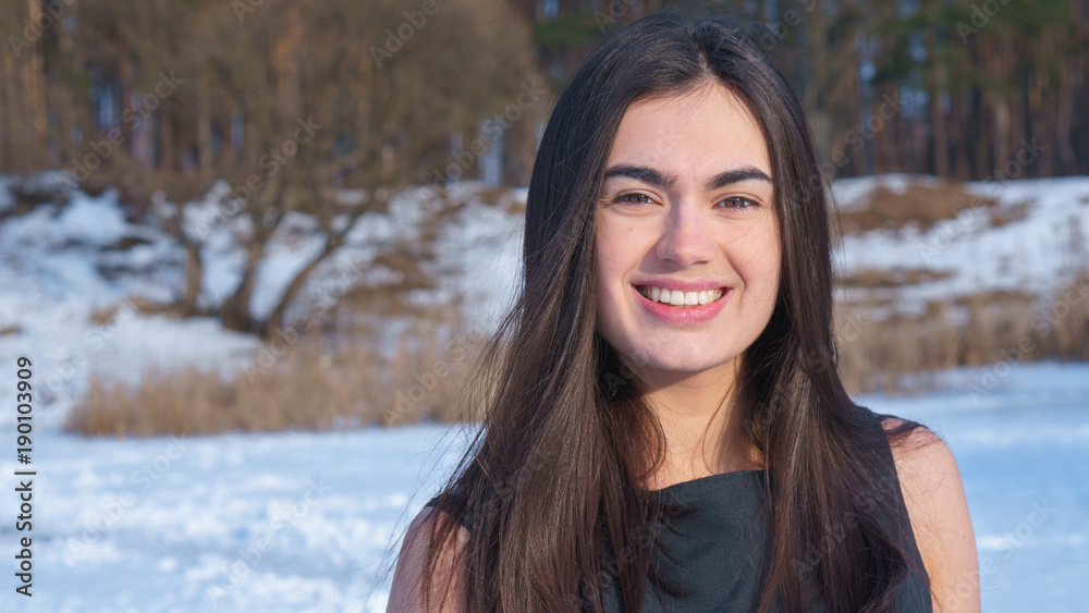 Portrait attractive smiling young brunette girl on a snowy landscape background Portrait attractive smiling young brunette girl on a snowy landscape background