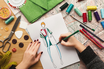 Top view on woman designer drawing clothes sketches