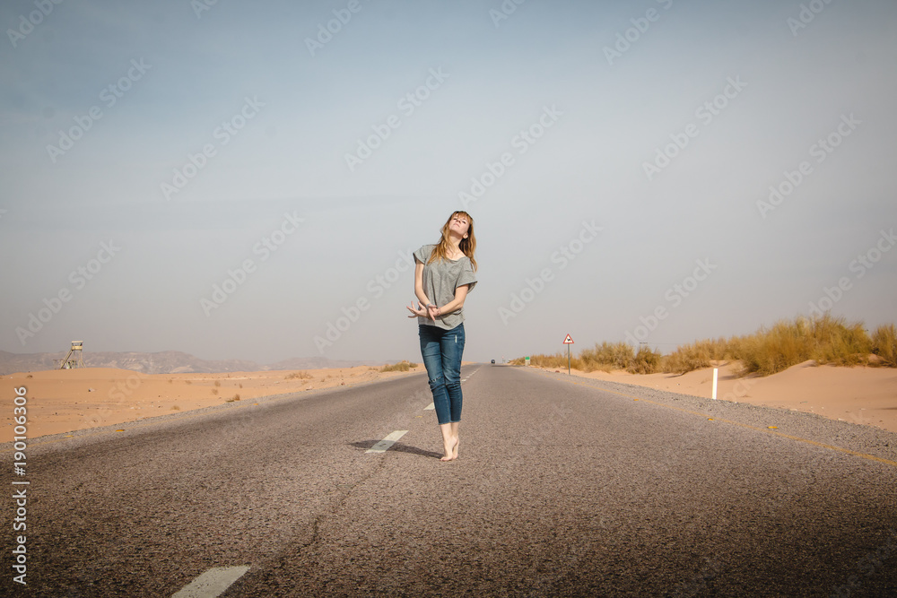 Girl have fun on the road in a desert Girl have fun on the road in a desert