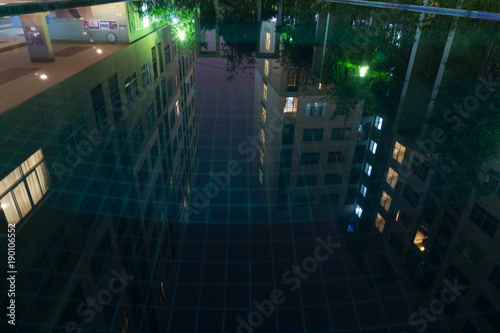 Reflex buildings from swimming pool in night scene