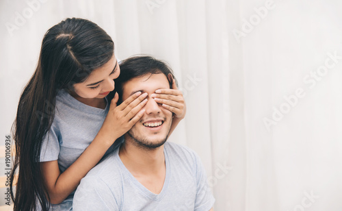 Happy Sweet Young Couple, She Closing Her Boyfriend's Eyes on the Bed in Bedroom  - Romantic and Surprise Moments © Platoo Studio