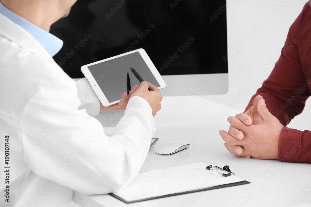 Fototapeta premium Male doctor consulting patient in clinic