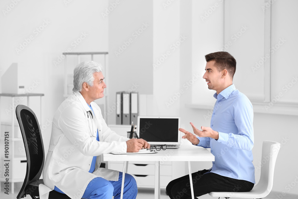 Male doctor consulting patient in clinic Male doctor consulting patient in clinic