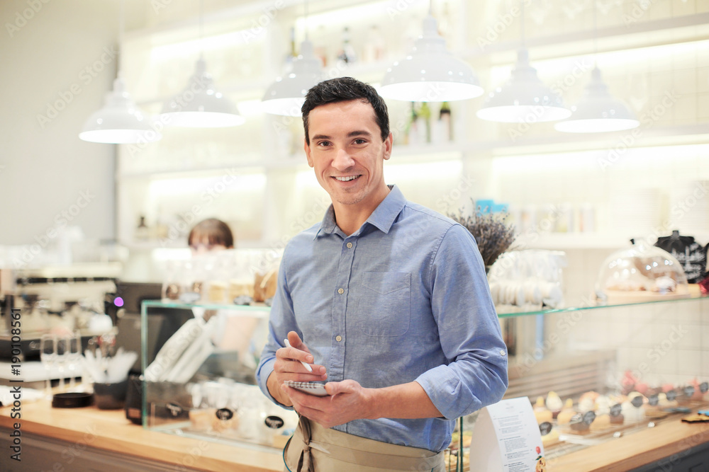 Attractive young waiter at workplace Attractive young waiter at workplace
