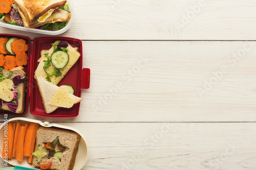 Various kunch boxes top view on white wooden boards photo