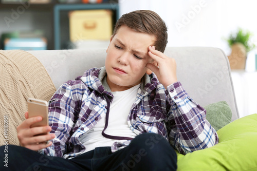 Upset teenage boy with smar...