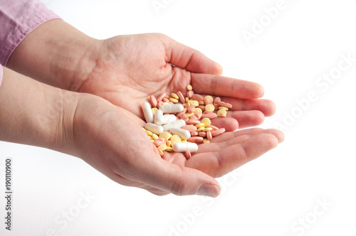 Many multi-colored pills in a Senior's hands on white background Alzheimer's patients caring for the health of the elderly patients