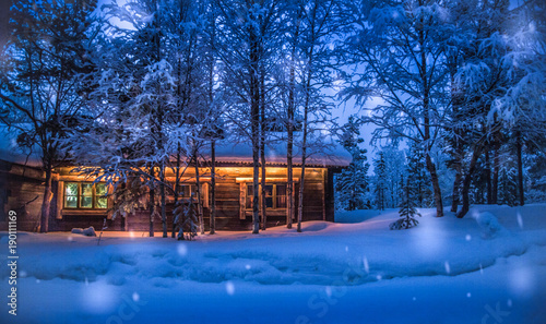 Obraz na płótnie Old wooden forest cabin in winter wonderland scenery at night w salonie