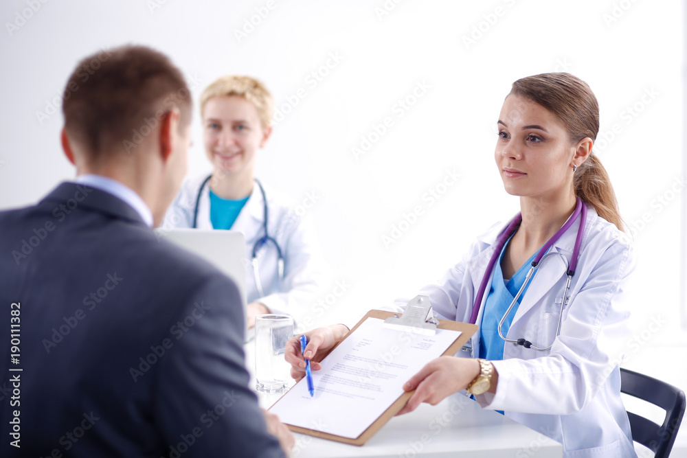 Women doctor and patient sitting at the desk in hospital. Women doctor Women doctor and patient sitting at the desk in hospital. Women doctor