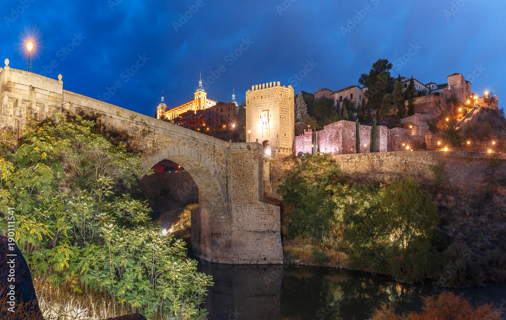 Old city of Toledo with Alcantara Bridge across the river Tajo and Alcazar at night, Castilla La Mancha, Spain