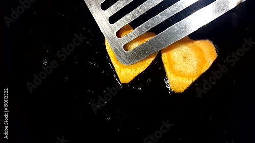 Fry carrots in the shape of heart in a frying pan photo