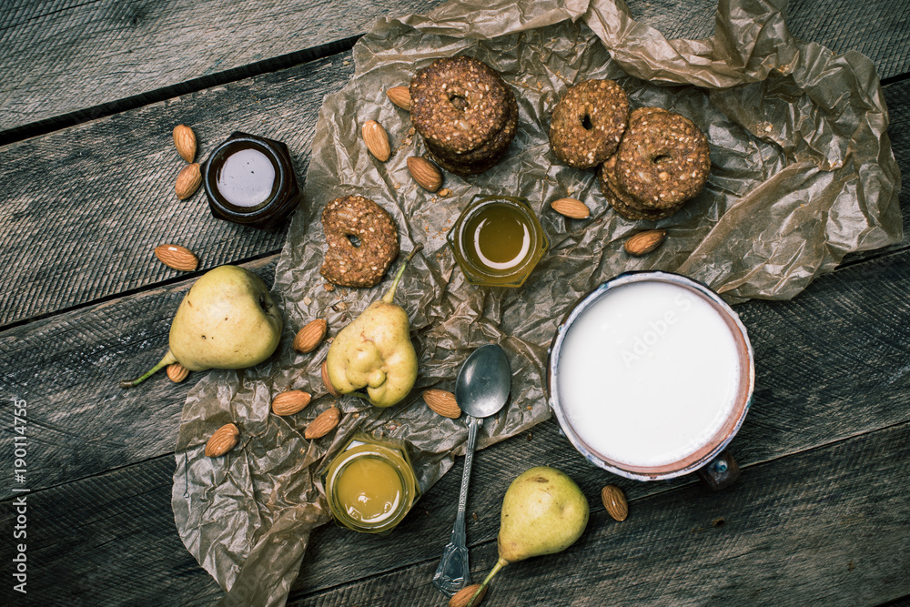 Tasty Pears almonds Cookies and milk on rustic wood