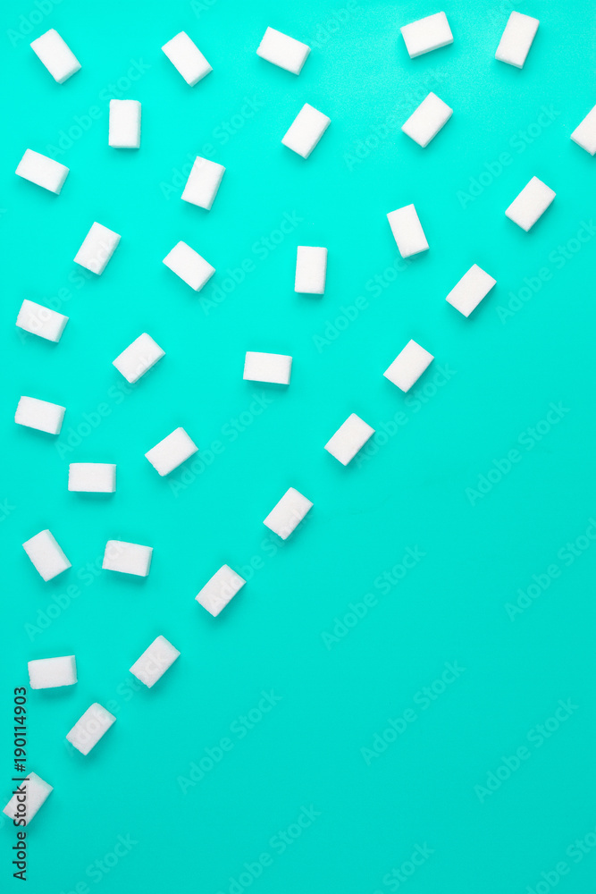 White sugar cubes arranged in diagonal lines on blue background